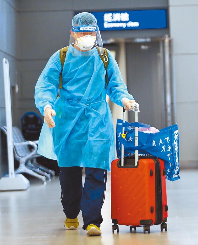 中央流行疫情指揮中心20日公布，國內新增1例境外移入新冠肺炎確定病例，在桃園機場入境管制區內，1名身穿防護衣的旅客準備通關入境。（范揚光攝）