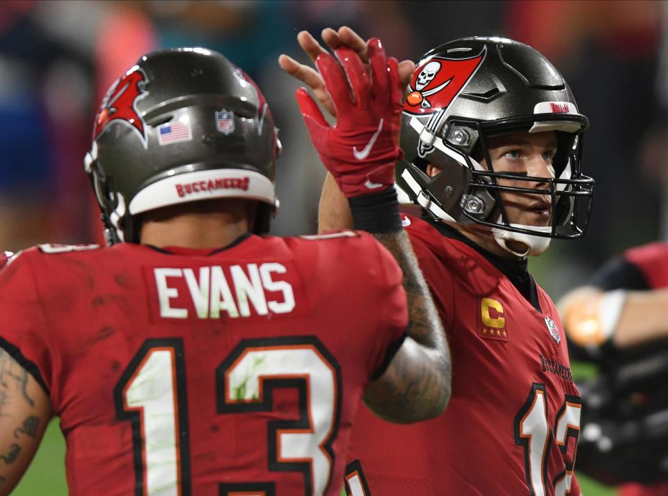 Tampa Bay Buccaneers quarterback Tom Brady (12) high fives wide receiver Mike Evans (13) after a touchdown against the Kansas City Chiefs during the second half of an NFL football game Sunday, Nov. 29, 2020, in Tampa, Fla. (AP Photo/Jason Behnken)