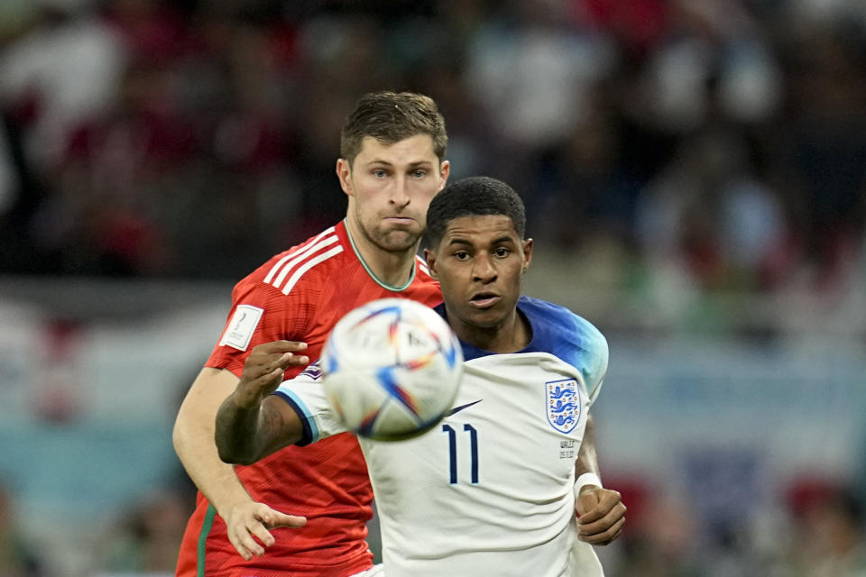 Wales' Ben Davies, left, and England's Marcus Rashford battle for the ball during the World Cup group B soccer match between England and Wales, at the Ahmad Bin Ali Stadium in Al Rayyan , Qatar, Tuesday, Nov. 29, 2022. (AP Photo/Abbie Parr)