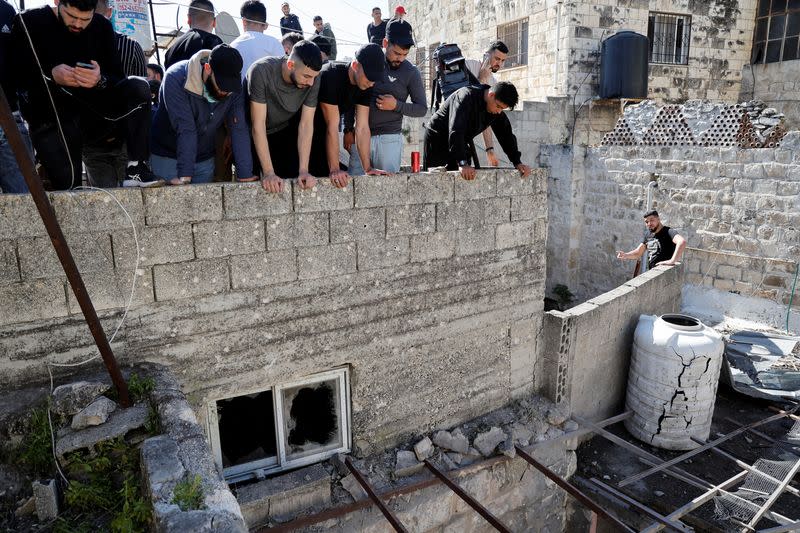 Palestinos revisan una casa dañada donde las fuerzas israelíes mataron a pistoleros palestinos en una redada, según el ejército israelí, en Naplusa, en la Cisjordania ocupada por Israel