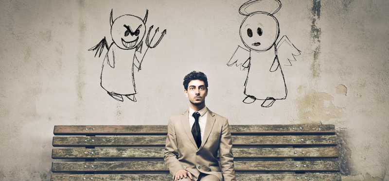 Man sitting on a bench with drawing of angel and demon over his shoulders.