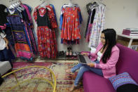 Mai Xiong, a new member of the Macomb County Board of Commissioners, attends a virtual meeting from her store in Warren, Mich., Thursday, April 29, 2021. Before last year’s election, she campaigned door to door, pulling her young children in a wagon behind her. She was heartened that the reaction in Warren, the city that includes her district, was largely positive. And she won handily, taking out an old-guard member of the board. (AP Photo/Paul Sancya)