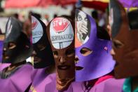 <p>Bangladeshi women wearing masks take part in a rally to mark International Women’s Day in Dhaka on March 8, 2018. Thousands of Bangladeshi women, nongovernmental organizations, and rights groups activists took to the streets demanding safer lives for women in the country as well as an improvement in their social conditions. (Photo: Munir Uz Zaman/AFP/Getty Images) </p>