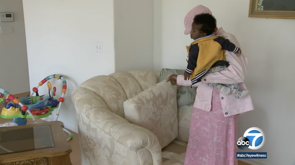 Vicky Umodu looking at the couch cushion.