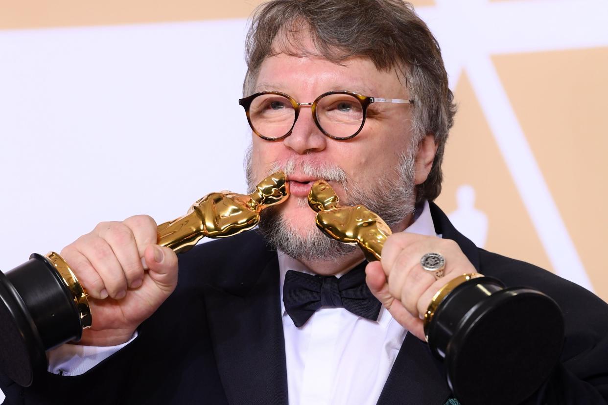 El director Guillermo del Toro besa sus dos estatuillas doradas ganadas en el 2018 por 