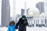 A woman and a child walk in Astana, Kazakhstan, on Monday, Jan. 23, 2017. Astana, the capital city of Kazakhstan, which is hosting Syria peace talks, is a relatively new name on the map. Founded in the early 19th century as a Russian empire outpost, Akmolinsk was a backwater in the wind-swept steppe. That changed in 1994 when Kazakhstan's first president decided to move the capital from the commercial center Almaty, and Akmolinsk was renamed Astana.(AP Photo/Sergei Grits)