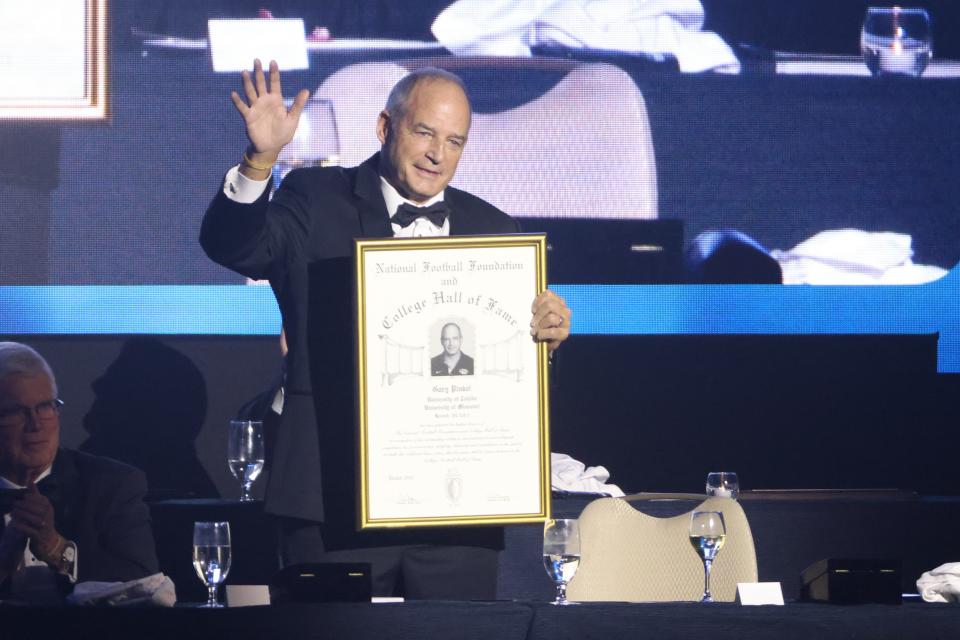 Legendary Missouri football coach Gary Pinkel eaves as he accepts his induction into the College Football Hall of Fame on Dec. 6, 2022, in Las Vegas, Nev.