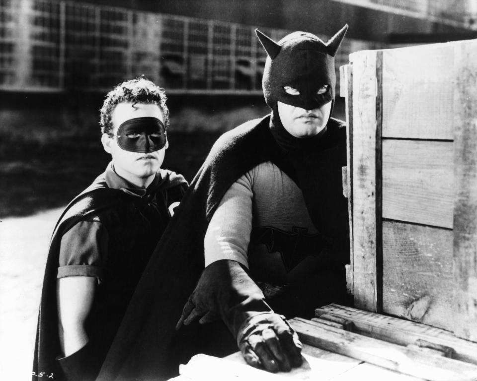 Douglas Croft and Lewis Wilson hide behind crates in a scene from the film 'Batman', 1943. (Photo by Columbia Pictures/Getty Images)