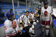 Members of the "1979" hockey club take a break between periods during a hockey match at a rink in Beijing, Wednesday, Jan. 12, 2022. Spurred by enthusiasm after China was awarded the 2022 Winter Olympics, the members of a 1970s-era youth hockey team, now around 60 years old, have reunited decades later to once again take to the ice. (AP Photo/Mark Schiefelbein)