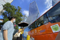 Residents pass in front of the Evergrande headquarters, center, in Shenzhen, China, Friday, Sept. 24, 2021. Seeking to dispel fears of financial turmoil, some Chinese banks are disclosing what they are owed by a real estate developer that is struggling under $310 billion in debt, saying they can cope with a potential default. (AP Photo/Ng Han Guan)