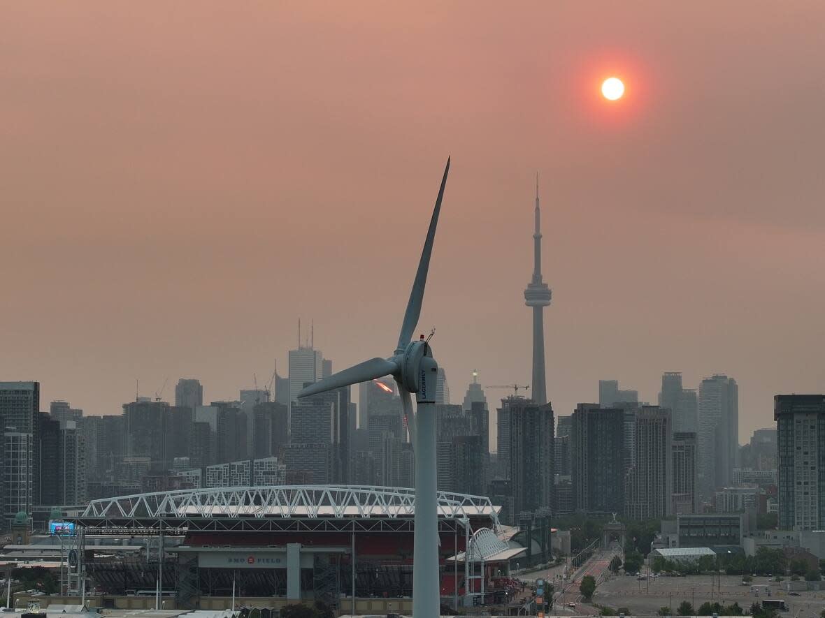 Smog and soot lingers over Toronto at sunrise due to smoke from forest fires raging in Quebec. (Patrick Morrell/CBC - image credit)