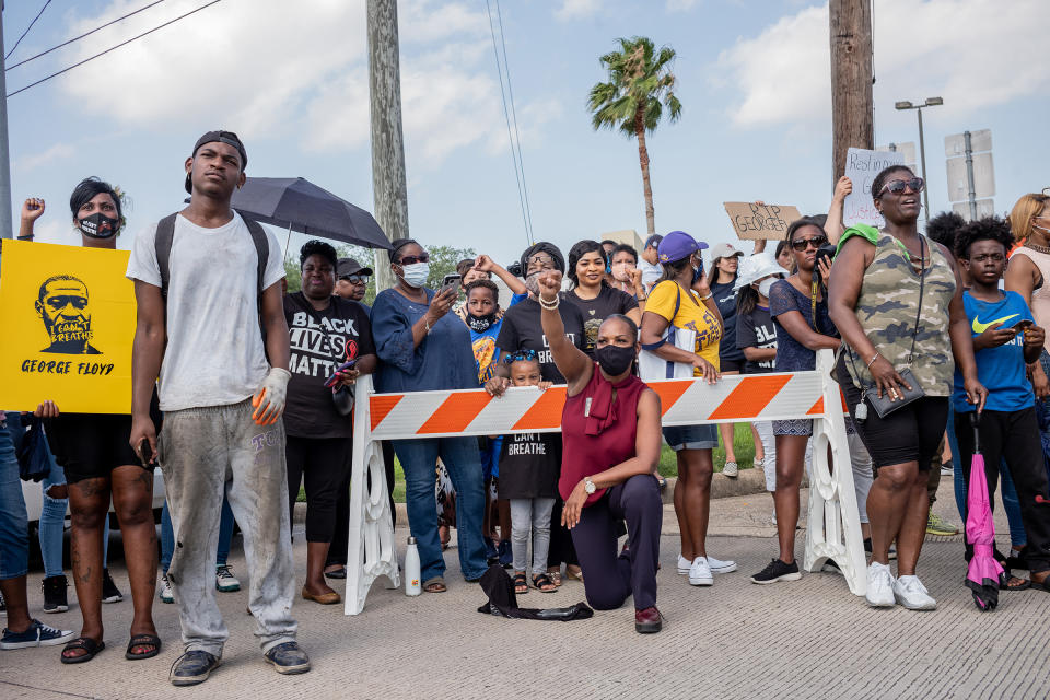 A woman takes a knee as George Floyd's <a href="https://time.com/5851608/george-floyd-funeral-photos/" rel="nofollow noopener" target="_blank" data-ylk="slk:funeral procession;elm:context_link;itc:0;sec:content-canvas" class="link ">funeral procession</a> enters the cemetery in Houston on June 9. "People were chanting George Floyd's name and 'no justice, no peace!'"<span class="copyright">Ruddy Roye for TIME</span>