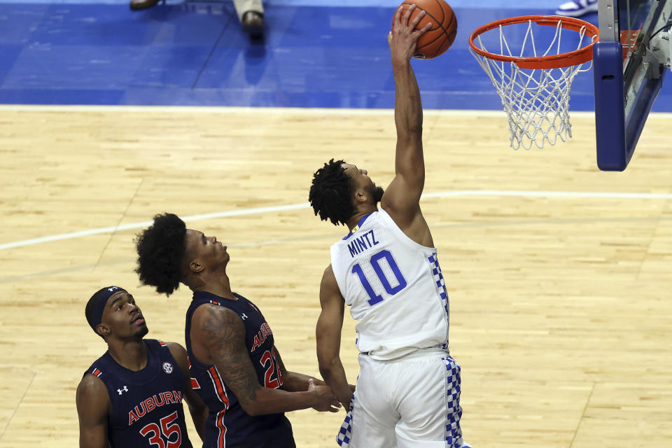 Kentucky's Davion Mintz (10) dunks in front of Auburn's Devan Cambridge (35) and Allen Flanigan during the second half of an NCAA college basketball game in Lexington, Ky., Saturday, Feb. 13, 2021. Kentucky won 82-80. (AP Photo/James Crisp)