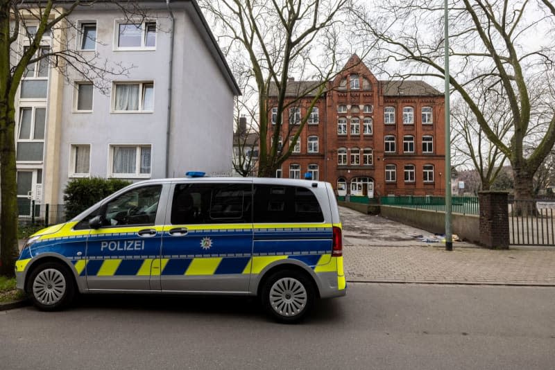 A police vehicle is parked in front of the school about 300 meters from the crime scene, where the children had fled after the attack. Christoph Reichwein/dpa