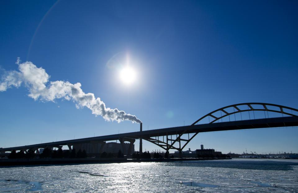 Steam is seen drifting from a factory over the Hoan Bridge as another round of arctic air blasts the midwest keeping the wind chill in the negative numbers, in Milwaukee, Wisconsin February, 6, 2014. REUTERS/Darren Hauck (UNITED STATES - Tags: ENVIRONMENT)