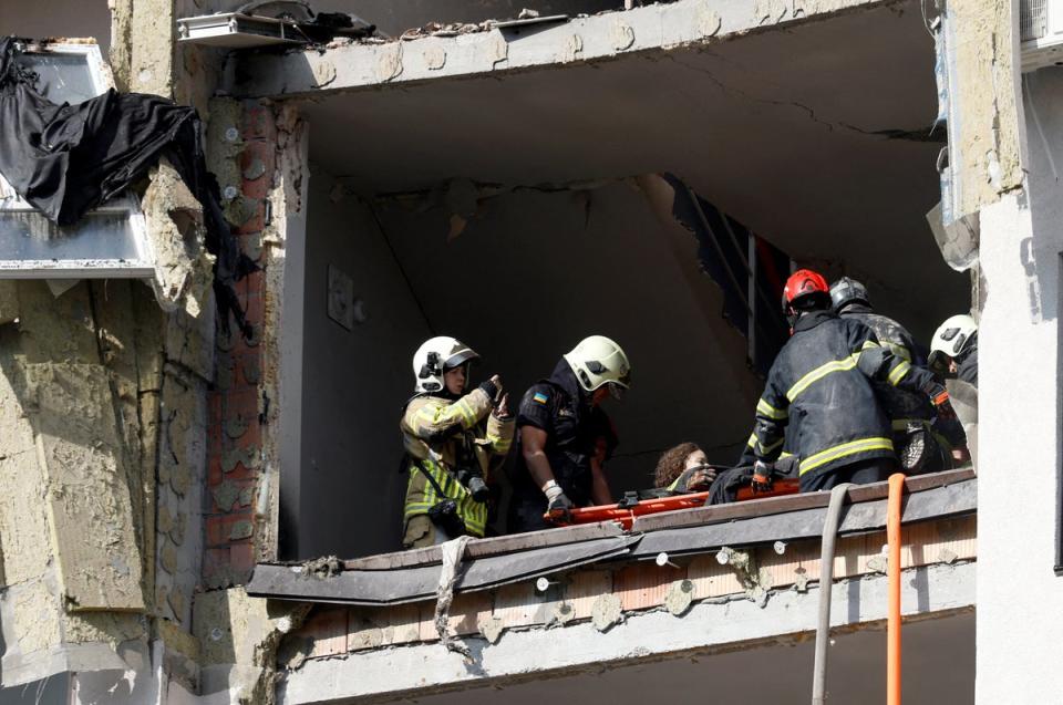 Rescue workers evacuate a person from a residential building damaged by a Russian missile strike (REUTERS)