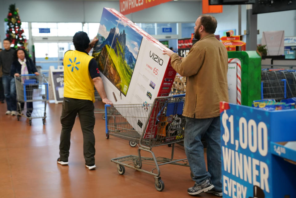 A man pushes a television in a shopping cart in Walmart on Black Friday, a day that kicks off the holiday shopping season, in King of Prussia, Pennsylvania, U.S., on November 29, 2019. REUTERS/Sarah Silbiger.