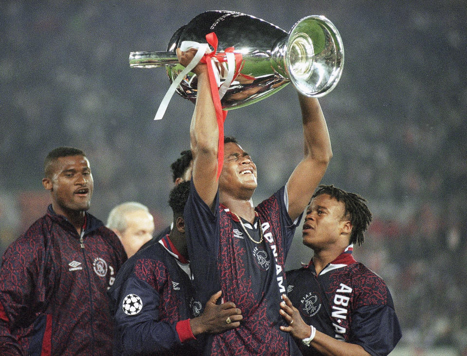FILE - In this Wednesday, May 24, 1995 file photo Ajax's Clarence Seedorf, partially hidden left, and Edgar Davids, right, hold on to goalscorer Patrick Kluivert, center, as he raises the trophy in joy after Ajax won the Champions League with a 1-0 victory over AC Milan in Vienna. Y is for Youngest. Kluivert is the youngest player to score in the Champions League final, when he did so in the 1995 final aged 18 years and 327 days old. (AP Photo/Luca Bruno, File)