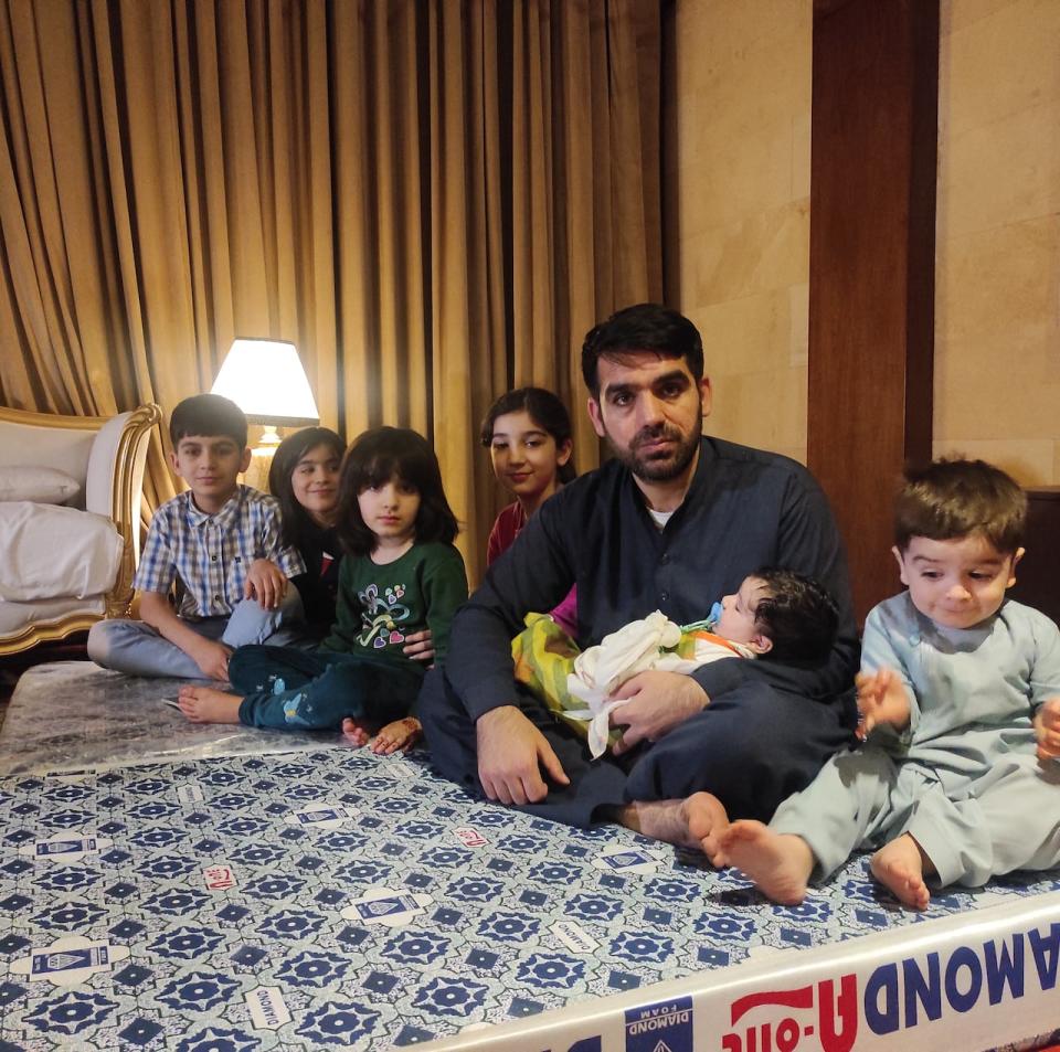 Mohammad Nasimi and his children pose in the hotel room in Islamabad where they're staying, until they can move to Canada.  