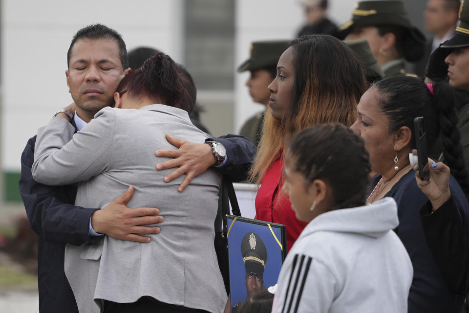 Relatives embrace during a ceremony marking one year since a car bomb attack on the police academy in Bogota, Colombia, Monday, Jan. 20, 2020, during the inauguration of a regional anti-terrorism summit attended by Colombian President Ivan Duque, US State Secretary Mike Pompeo and Venezuela's opposition leader Juan Guaido. Colombian government blamed rebels of the National Liberation Army, ELN, for the bombing that killed at least 21 people on Jan. 17, 2019. (AP Photo/Ivan Valencia)