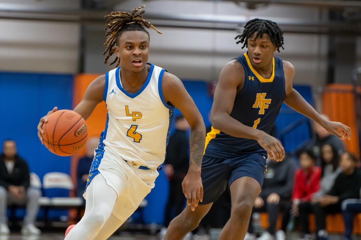 Mikey Crawford (4) drives into the lane as Ephraim Strong (1) trails him in Lincoln Park’s 2024 Burger King Classic semifinal matchup against Niagara Falls Friday night.