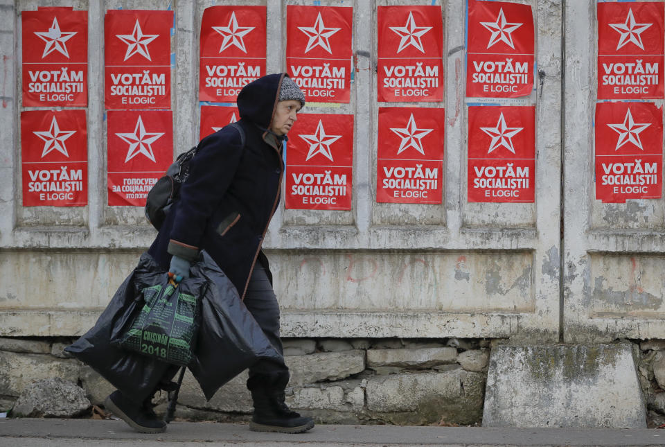 A woman walks by electoral posters advertising the candidates of the Socialists' Party Chisinau, Moldova, Thursday, Feb. 21, 2019, ahead of parliamentary elections taking place on Feb. 24. Moldova's president says the former Soviet republic needs good relations with Russia, amid uncertainty about the future of the European Union. (AP Photo/Vadim Ghirda)