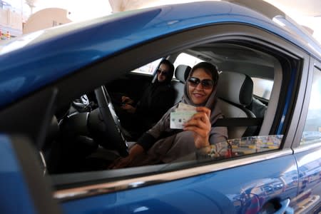 Saudi woman shows her national ID at the Bahrain immigration checkpoint, as she drives to Bahrain on the King Fahd Causeway