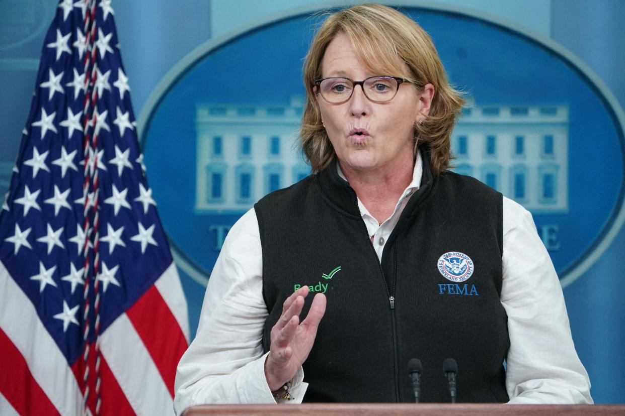 FEMA Administrator Deanne Criswell speaks from a podium at the White House, with an American flag in the background.. 