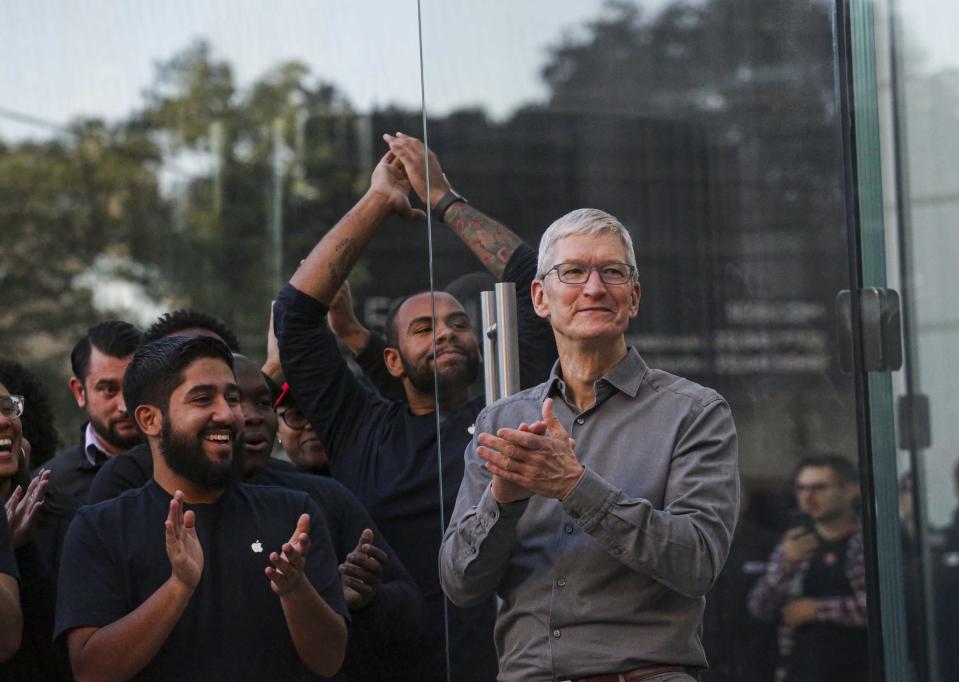 Tim Cook con unos empleados de Apple (Photo credit should read KENA BETANCUR/AFP via Getty Images)