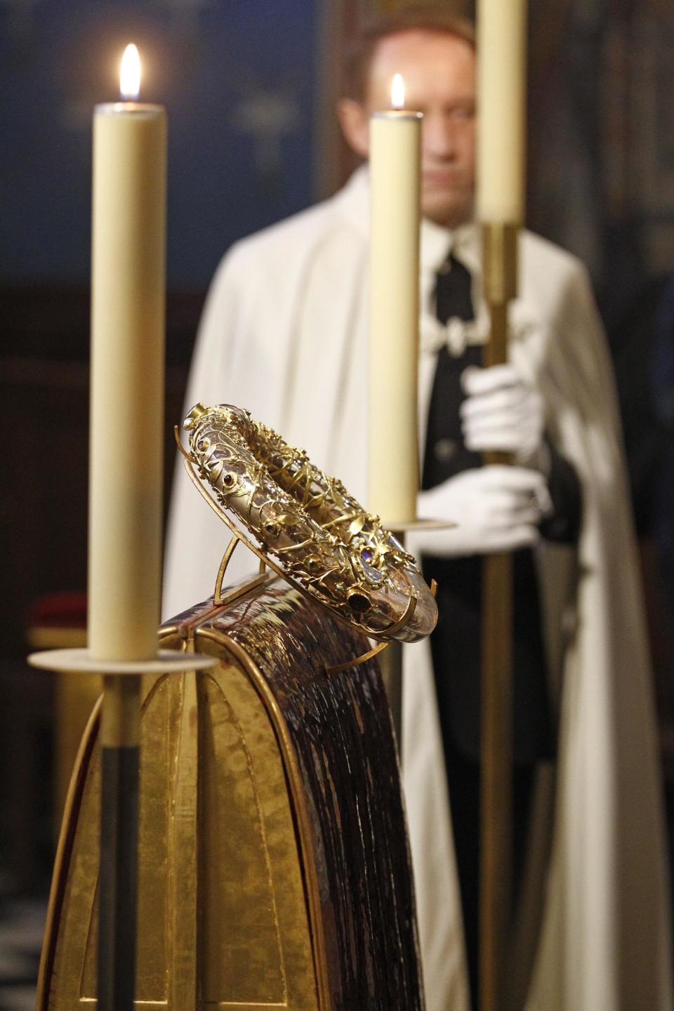 A knight of the Order of the Holy Sepulchre stands near a crown of thorns which was believed to have been worn by Jesus Christ and which was bought by King Louis IX in 1239 is presented at Notre Dame Cathedral in Paris, Friday March 21, 2014. To mark the 800th anniversary of Louis IX's christening, the crown of thorns will be displayed outside Notre Dame, at the Collegiate Church of Poissy, where King Louis IX was christened. (AP Photo/Remy de la Mauviniere)