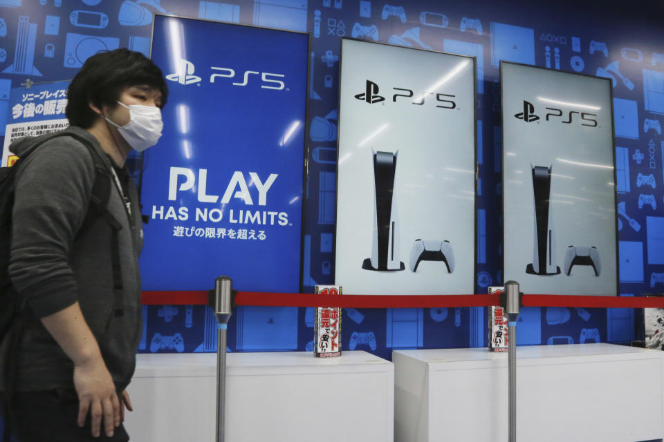 A man stands near promotional pictures of Play Station 5 at an electronics retail chain store in Tokyo, Wednesday, April 28, 2021. Sony’s January-March profit zoomed eight-fold to 107 billion yen ($982 million) as people stuck at home during the coronavirus pandemic turned to the Japanese electronics and entertainment company’s video games and other visual content. (AP Photo/Koji Sasahara)