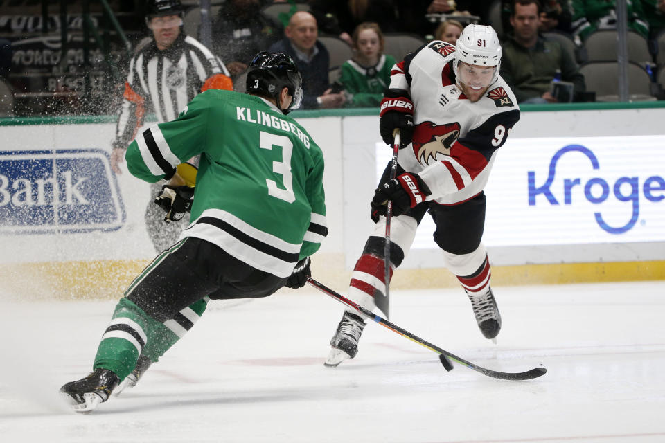 Arizona Coyotes left wing Taylor Hall (91) takes a shot on goal as Dallas Stars' John Klingberg (3) defends during the second period of an NHL hockey game in Dallas, Wednesday, Feb. 19, 2019. (AP Photo/Michael Ainsworth)