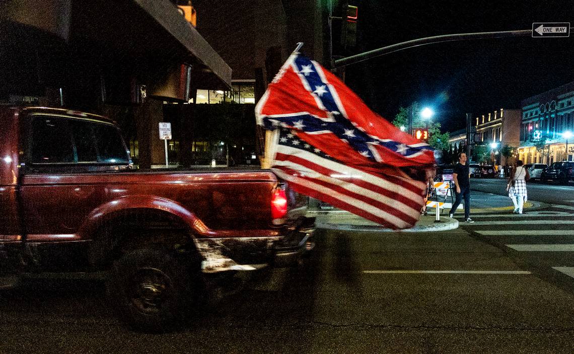 A truck with an American flag and a Confederate flag drives on Capitol Boulevard on Aug. 19. Loud vehicles circling the downtown blocks of Boise are a common sight and sound on Friday and Saturday nights.