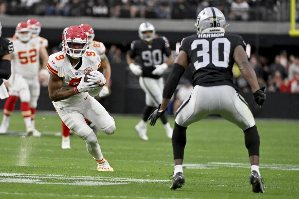 Kansas City Chiefs wide receiver JuJu Smith-Schuster (9) runs with the ball as Las Vegas Raiders safety Duron Harmon (30) defends during the first half of an NFL football game Saturday, Jan. 7, 2023, in Las Vegas. (AP Photo/David Becker)