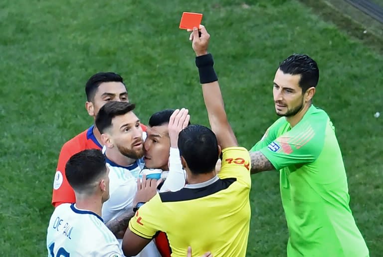 El árbitro paraguayo Mario Díaz de Vivar muestra la tarjeta roja al argentino Lionel Messi y al chileno Gary Medel mientras tienen una pelea durante el partido por el tercer puesto de la Copa América 2019 en Sao Paulo, Brasil, el 6 de julio (EVARISTO SA)
