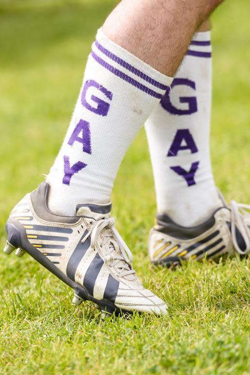 Berlin Bruisers captain Colin Comfort wears socks reading "Gay" on them during a training with Welsh rugby player Gareth Thomas on May 23, 2014 in Berlin