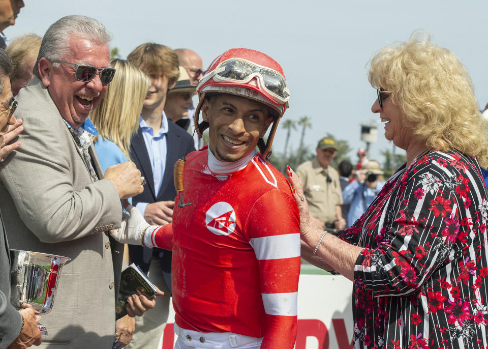 In a photo provided by Benoit Photo, Practical Move co-owners Pierre and Leslie Amestoy congratulate jockey Ramon Vazquez after the horse's win in the Grade I, $750,000 Santa Anita Derby horse race Saturday, April 8, 2023, at Santa Anita in Arcadia, Calif. (Benoit Photo via AP)