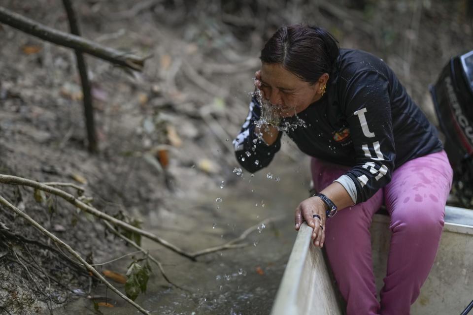 Mandei Juma splashes her face as she rides a boat on the Assua River in the Juman Indigenous community, in Canutama, Amazonas state, Brazil, Saturday, July 8, 2023. Along with two sisters, Mandei leads and manages the Indigenous territory after the death of their father in 2021. (AP Photo/Andre Penner)