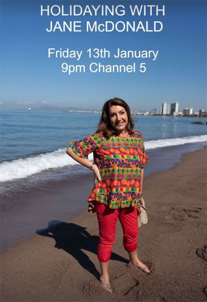 Jane McDonald in a bright shirt and red jeans