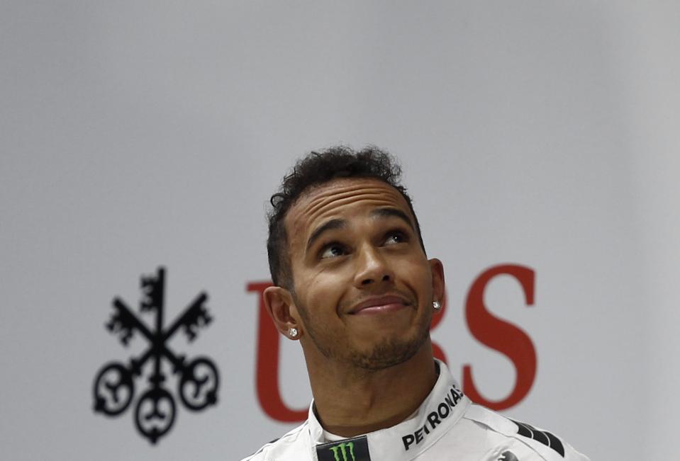 First-placed Mercedes Formula One driver Hamilton of Britain looks up as he stands on the winners' podium during the Chinese F1 Grand Prix at the Shanghai International circuit