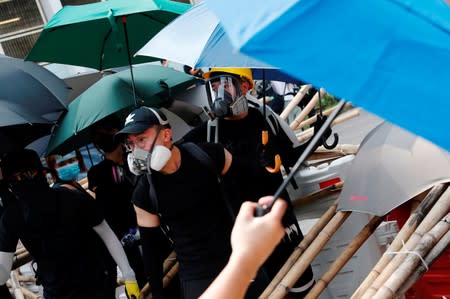Anti-extradition bill protesters set up barriers as they standoff with riot police during a march to demand democracy and political reforms, at Kowloon bay, in Hong Kong