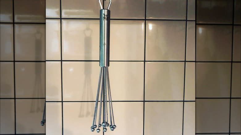 WMF ball whisk hanging in front of tiles