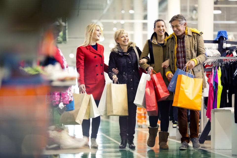 family carrying shopping bags in mall