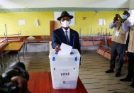 Ivory Coast President Alassane Ouattara casts his vote at a polling station during the legislative election in Abidjan