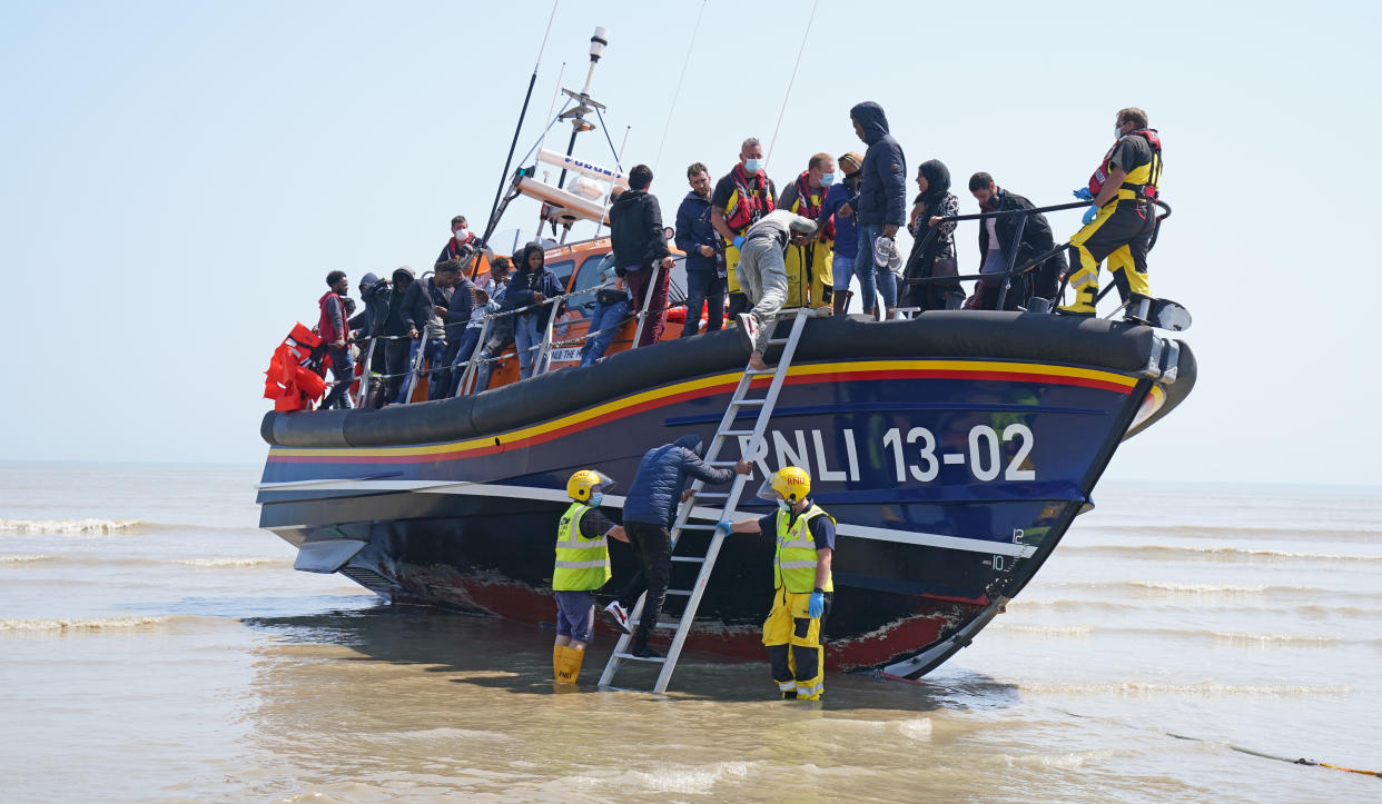 A group of people thought to be migrants crossing from France come ashore from the local lifeboat at Dungeness in Kent, after being picked-up following a small boat incident in the Channel. Picture date: Tuesday July 20, 2021.