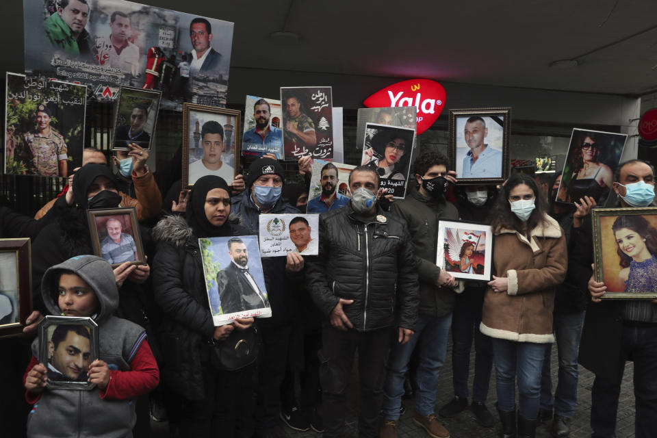 Relatives of victims of the Aug. 4, 2020 Beirut port explosion hold portraits of their loved one who killed during the explosion, during a sit-in outside the Justice Palace, in Beirut, Lebanon, Friday, Feb. 19, 2021. The prosecutor investigating last year's massive blast in Beirut was formally notified Friday that he would no longer lead an enquiry into last year's deadly port explosion, state-run Lebanon's National News Agency reported. (AP Photo/Bilal Hussein)