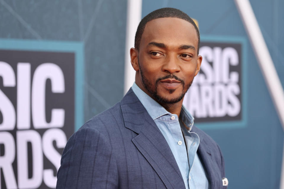 Anthony Mackie at a red carpet event wearing a blue suit and looking to his left