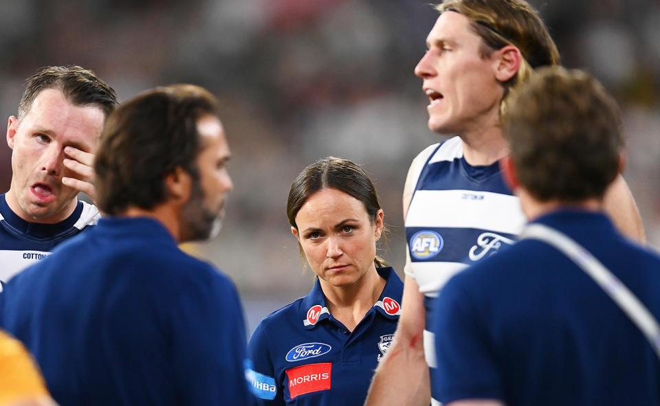 Daisy Pearce, pictured here looking on as head coach Chris Scott talks to Geelong players.