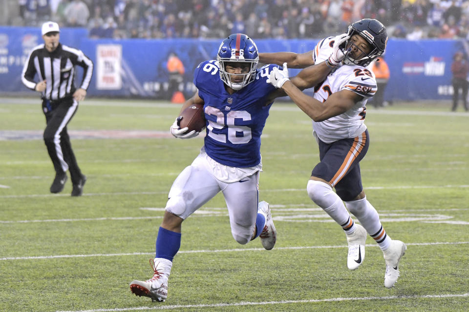 New York Giants running back Saquon Barkley (26) stiff arms Chicago Bears cornerback Kyle Fuller (23) during the second half of an NFL football game, Sunday, Dec. 2, 2018, in East Rutherford, N.J. (AP Photo/Bill Kostroun)