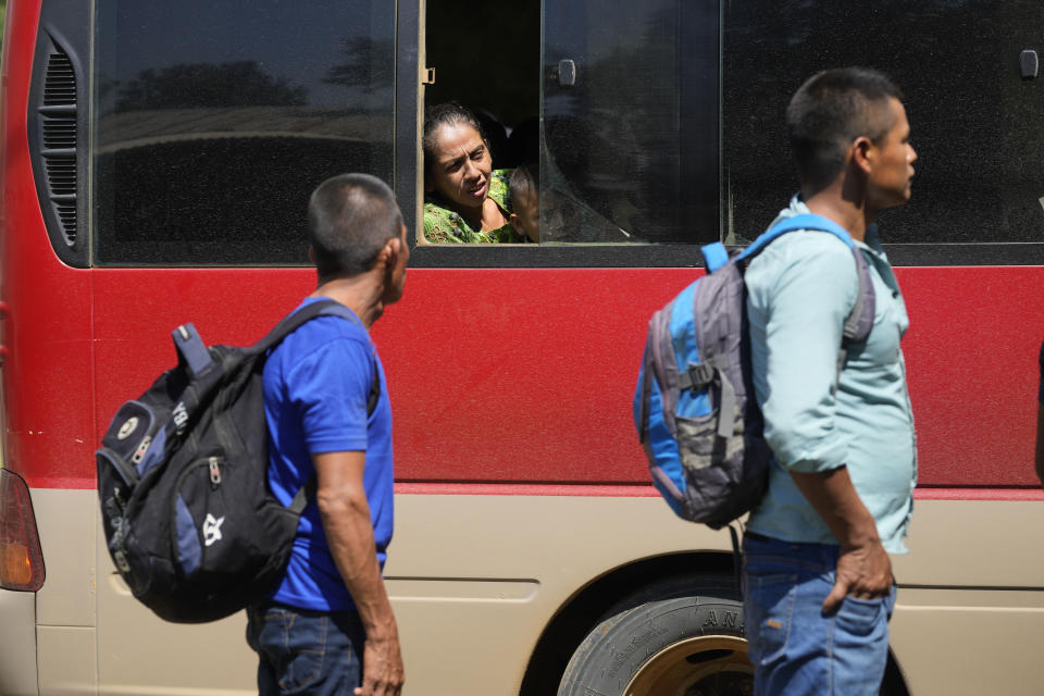 Bus passengers wait to be inspected by police at a check point in El Estor in the northern coastal province of Izabal, Guatemala, Monday, Oct. 25, 2021. The Guatemalan government has declared a month-long, dawn-to-dusk curfew and banned pubic gatherings following protests against a nickel mining project. (AP Photo/Moises Castillo)